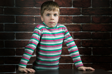 six year old boy with a surprised expression on the wallの写真素材