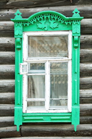 wooden window and log wall of an old houseの写真素材