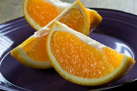 sliced three orange slices on a rustic table closeupの写真素材