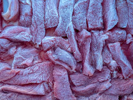 Slices of frozen beef meat thawed on a food trayの写真素材