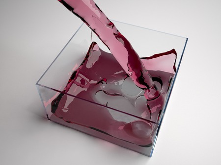 Pouring red liquid in a glass cubeの写真素材