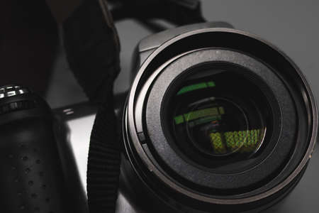 A small ordinary camera with a built-in zoom lens. close to the glass. Glare and details. The...