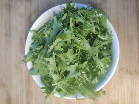 fresh salad greens in a plate on the table
