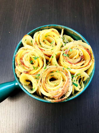 baked potatoes with sauce and spices in a porcelain cupの写真素材
