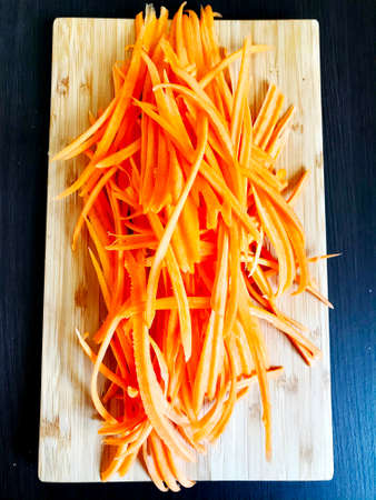 ready-to-cook grated carrots on a wooden tableの写真素材