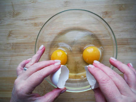 Female hands break an egg, cooking egg dishes
