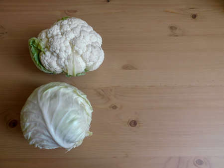 white cabbage and cauliflower on a wooden tableの写真素材
