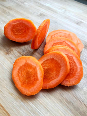 Carrots cut several pieces on a wooden cutting boardの写真素材