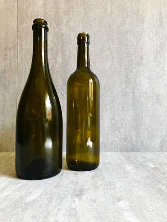two dark wine bottles stand on the tableの写真素材