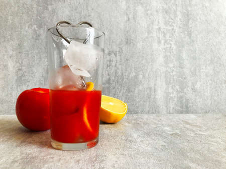 a glass of tomato juice and fresh peppers on the tableの写真素材