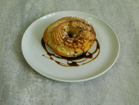 fresh organic homemade bagel with cream and powdered sugar on a plate