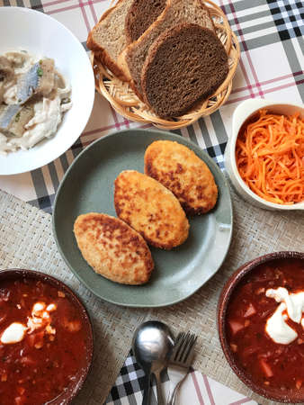 traditional Russian lunch, borscht, cutlets, fresh salad and black bread on the table.の写真素材