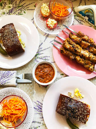 homemade lunch with shish kebab, meat pie, sauce and fresh salad