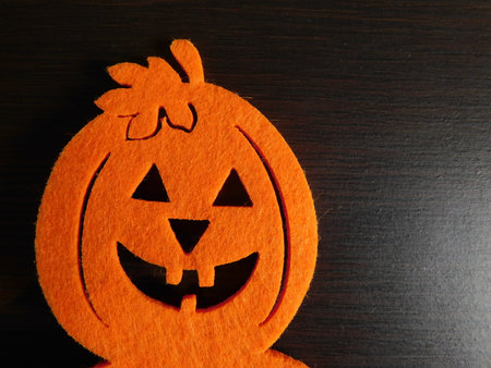 Whimsical Halloween background image of handmade felt jack-o-lantern on rustic wood with twine and burlap.の写真素材