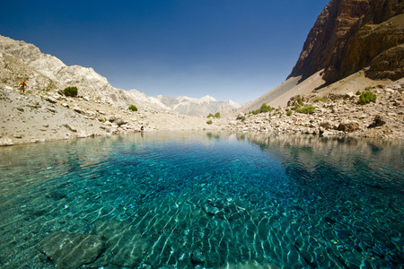 blue mountain lake at sunrise surrounded by high peaksの写真素材