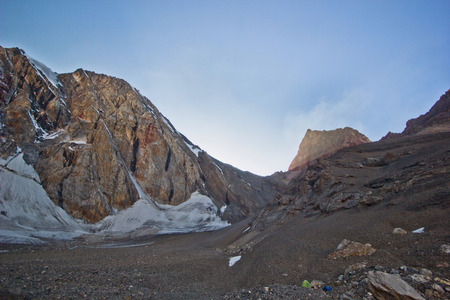 sunset at camping in the mountains with snowy rocks sorroundedの写真素材