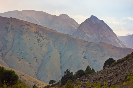 background layered mountain hills with grass at sunsetの写真素材