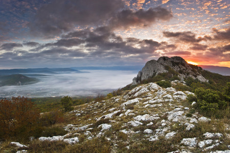 red sunrise in the mountains with clouds on earthの写真素材