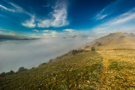 creeping fog in mountain valley at sunset with colorful skyの写真素材