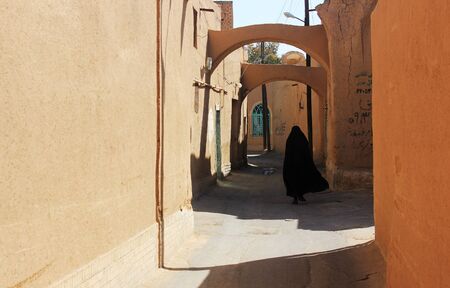 iranian women in black chador on the yazd streetの写真素材