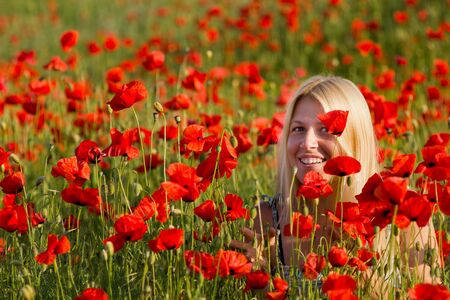 girl on red poppy field in summerの写真素材