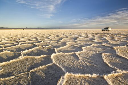 sunset panorama on Uyuni saline, Bolivia, salar lake, with cells on the groundの写真素材