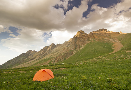 camping in high mountains at sunset with many clouds in the skyの写真素材