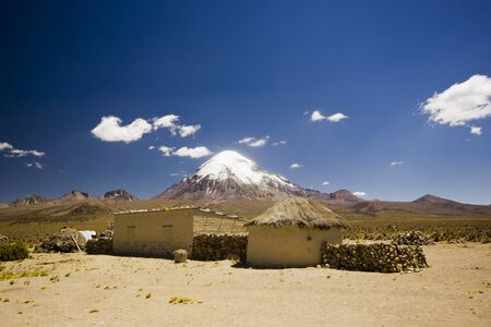 small village, several huts, in bolivia near snow covered volcano Sajama in altiplano desert