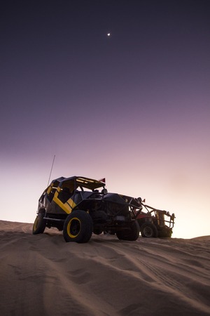 buggy on sand dunes at purple sunset in huacachina, peruの写真素材