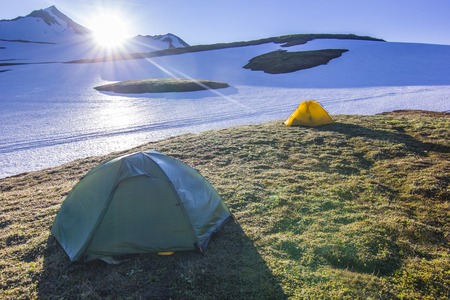 yellow tent against sun near volcanoes of Kamchatkaの写真素材