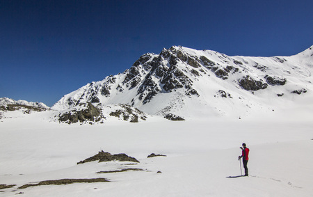 man standing on snow field in mountains at daylightの写真素材