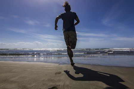 man running to the water of mediterranean seaの写真素材