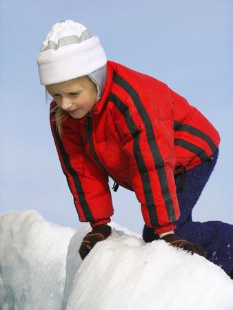 Young girl looking into the crack in the ice fieldの写真素材