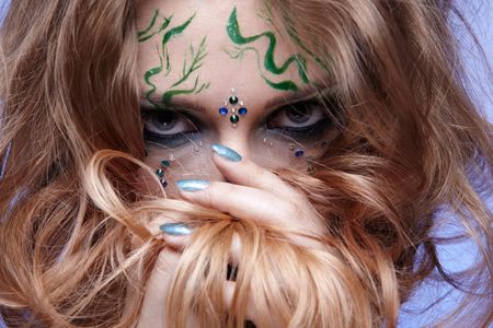 portrait of beautiful girl with bodyart of algae posing on blue and hiding her face in hairの写真素材
