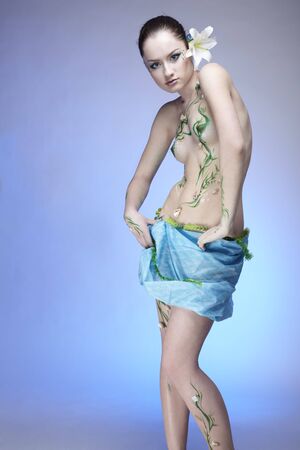 portrait of beautiful girl with mermaid bodyart on blueの写真素材