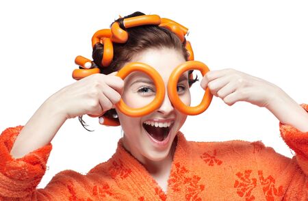 portrait of beautiful girl in orange bathrobe with orange head rollers in hairの写真素材