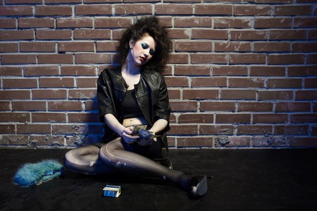 portrait of girl dressed like hooker posing near brick wallの写真素材