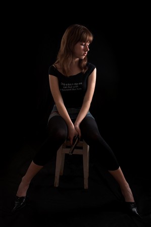 Girl with gun isolated at the black backgroundの写真素材