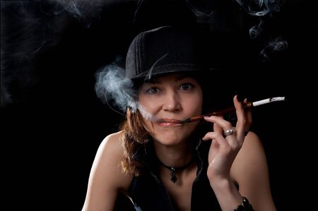 Woman in hat with cigarette holder isolated on the black backgroundの写真素材