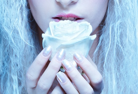 close-up portrait of beautiful blonde frozen fairy nymph girl with white roseの写真素材