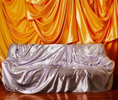 sofa covered with silver silk cloth, wall decorated with golden silk on backgroundの写真素材