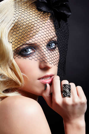 glamour portrait of beautiful blonde retro girl in veil on dark