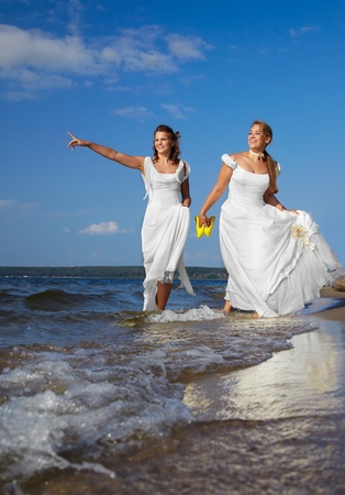 two beautiful slavonic brides walking along coastal stripの写真素材