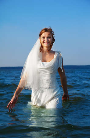 beautiful slavonic bride walking in sea wavesの写真素材