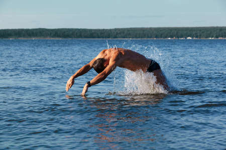man swimmer comes up from water to dive in it.の写真素材