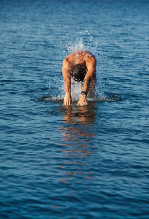 man swimmer comes up from water to dive in it.の写真素材