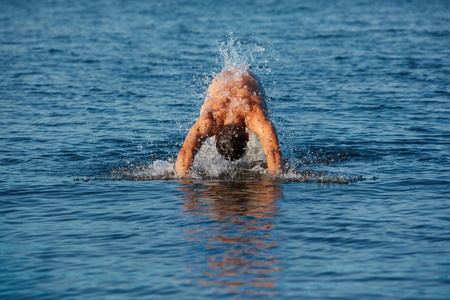 man swimmer comes up from water to dive in it.の写真素材