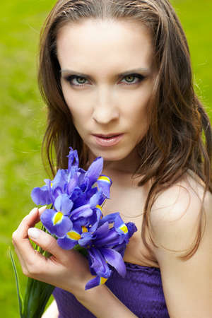 outdoor portrait of beautiful woman with blue iris flowers in handsの写真素材