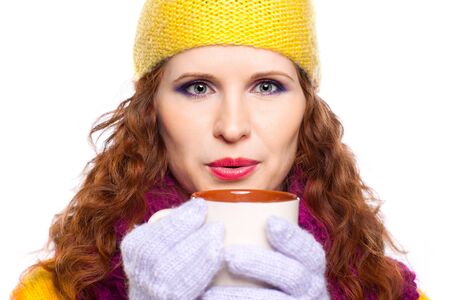 Young woman wearing winter clothes with cup of hot chocolate or coffee or tea