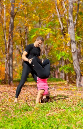 An attractive  man and woman practice Yoga in forest